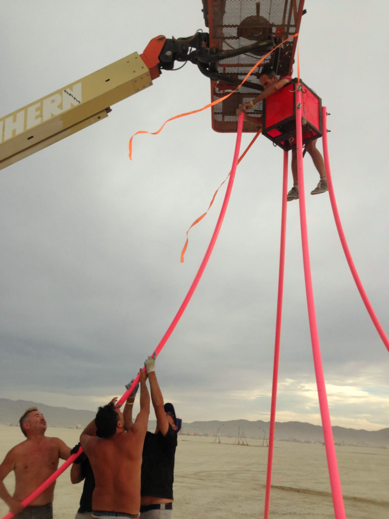 Working over the top of the Dream Swing from a boom lift basket, pink arcs running to the ground below