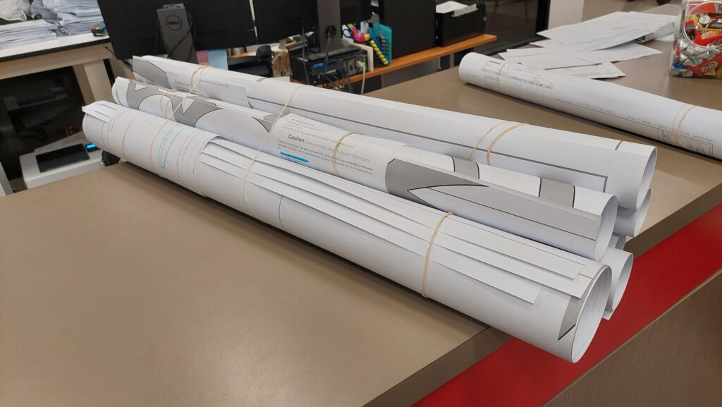 Rolled printed strips of the pattern lying on the counter of a wide-format reprographics shop