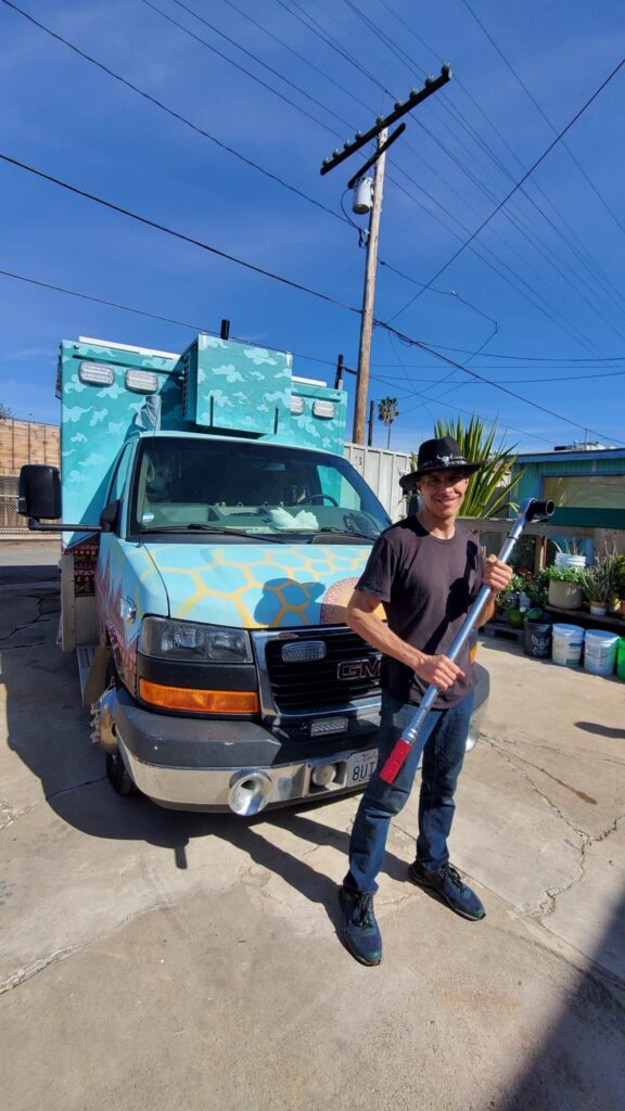 Standing in front of the ambulance conversion holding a breaker bar roughly four feet long, borrowed to break loose and retorque the crankshaft bolt