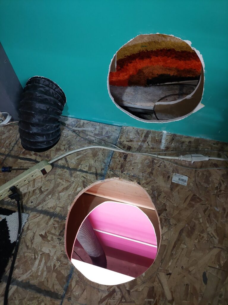 The laser exhaust ducting as it was: large freehand-cut openings in the floor and up the wall, with the tight corner it was rerouted into visible alongside