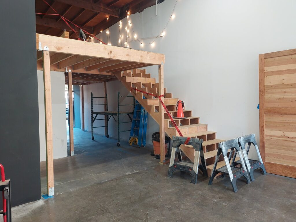 The new staircase installed: a single straight run from the shop floor to the mezzanine, no turn in it