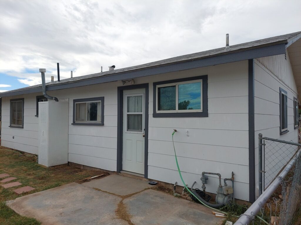 The same view painted and trimmed, the siding sound and the yard cleared