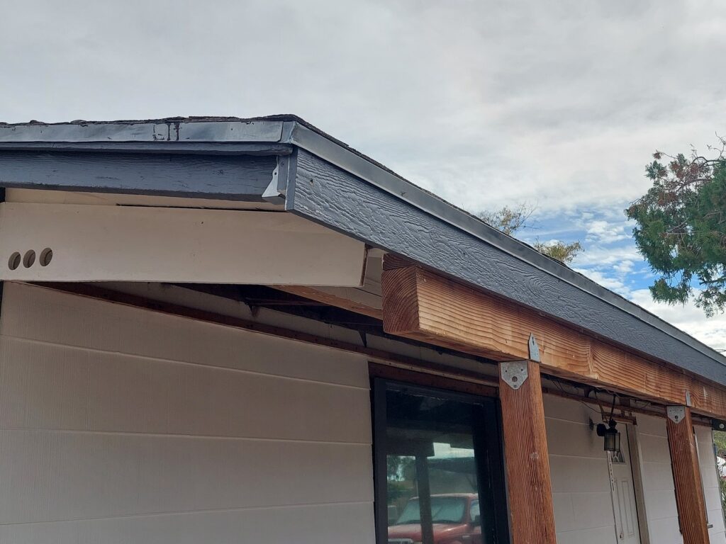 The same corner rebuilt, with new fascia, dark trim and flashing above it