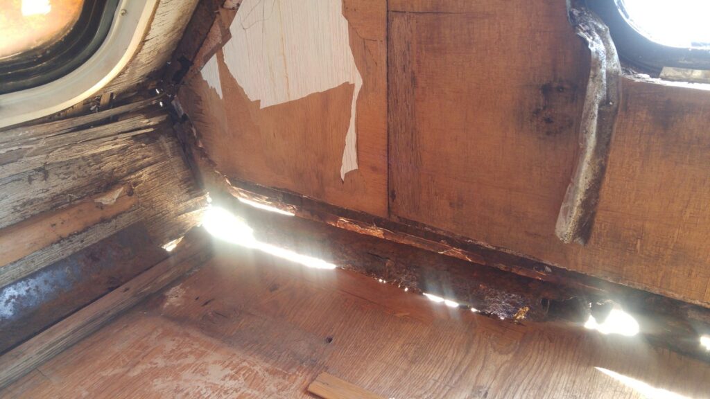 Rusted-through cabover frame with daylight visible where solid steel should be