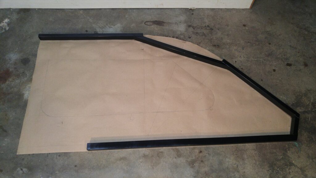 A section of new steel frame laid out and tack-welded directly on a full-size paper template on the ground