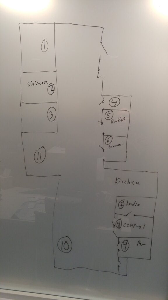 A whiteboard floor plan of an office suite drawn in marker, rooms numbered one to eleven, with the audio room and control room labelled